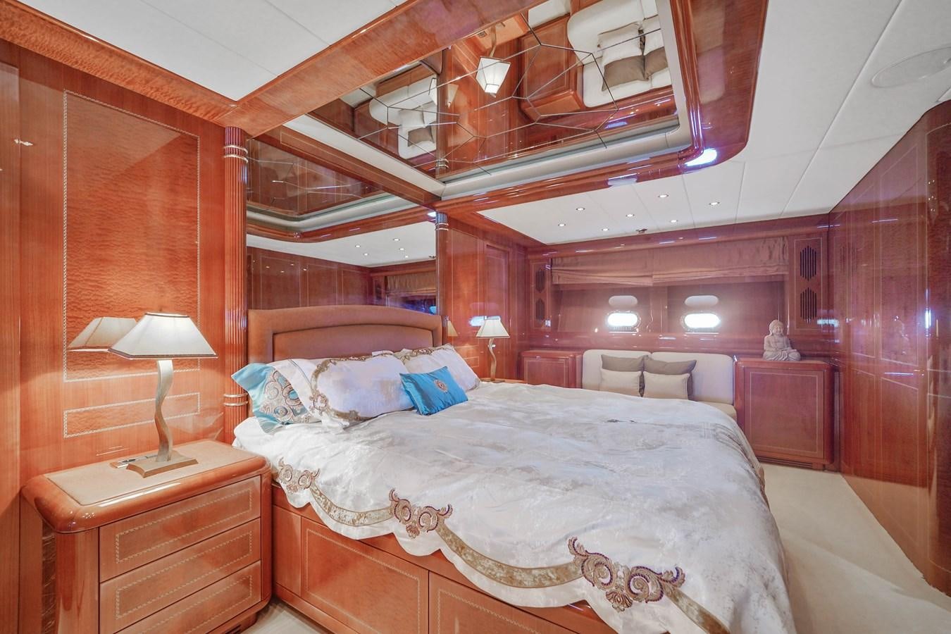 a bedroom with a bed and a lamp aboard 108' MANGUSTA 2002 Yacht for Sale