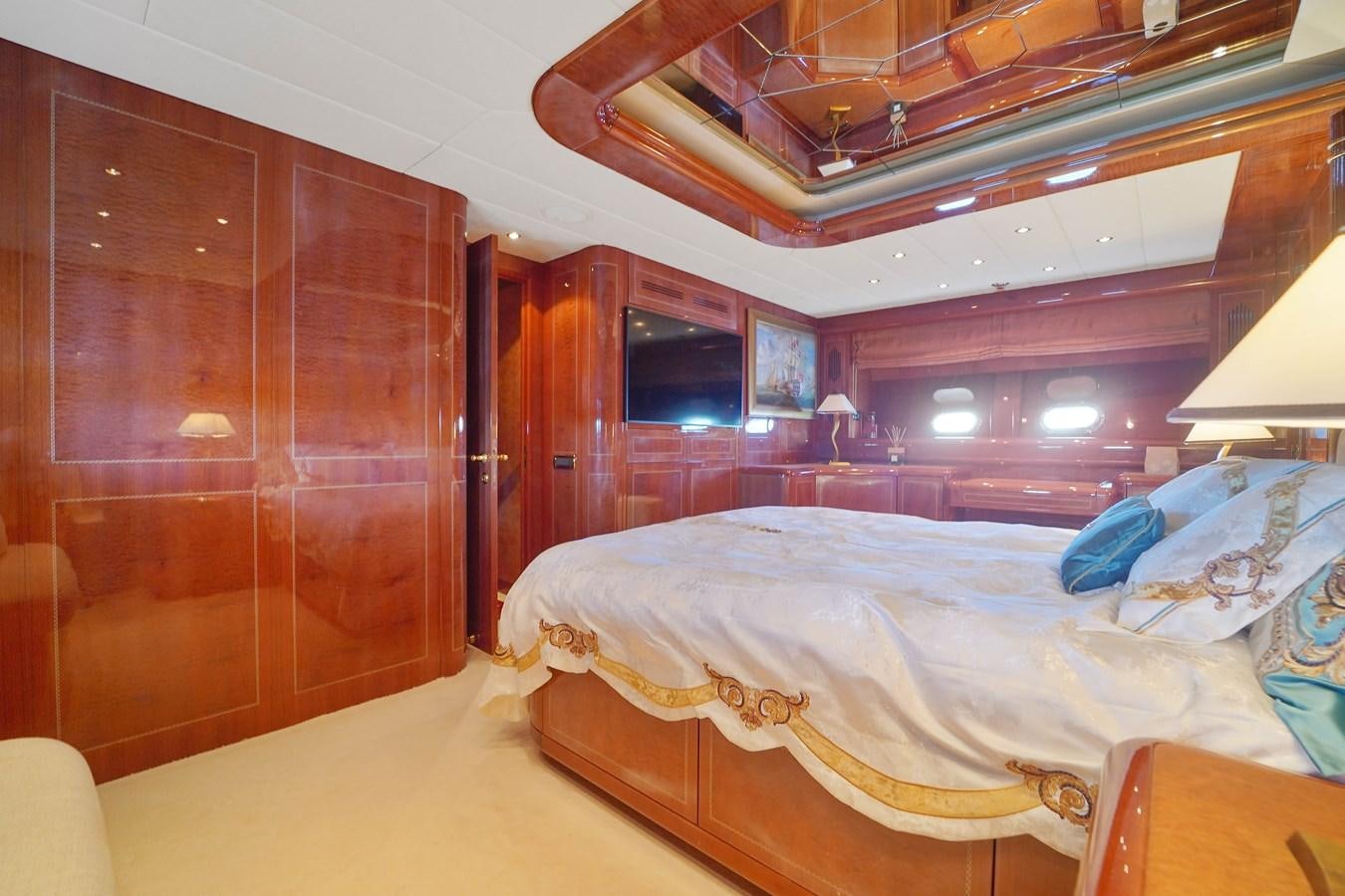 a room with a bed and a wood cabinet aboard 108' MANGUSTA 2002 Yacht for Sale