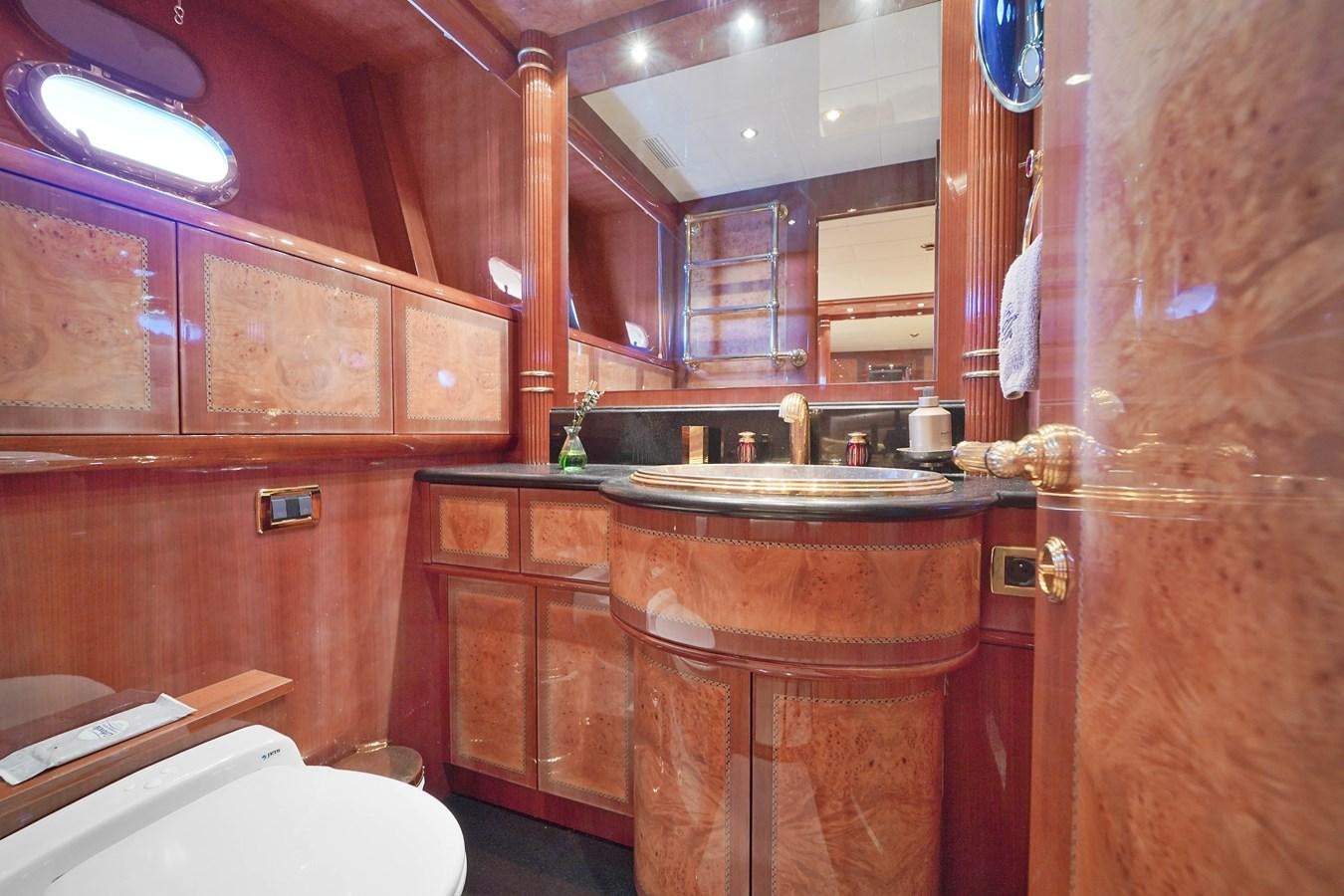 a bathroom with wooden cabinets aboard 108' MANGUSTA 2002 Yacht for Sale