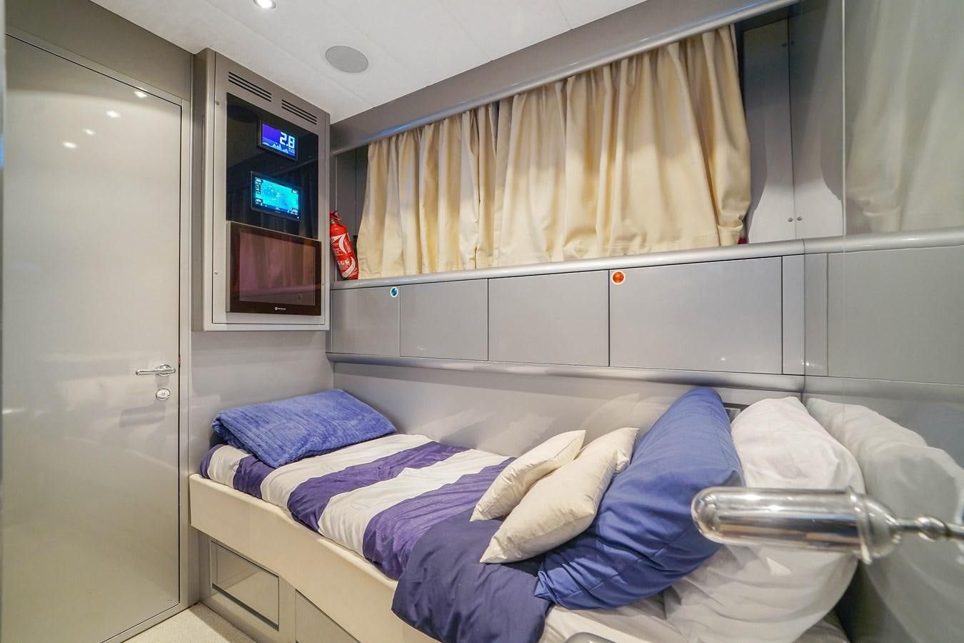 a room with a bed and a television aboard 108' MANGUSTA 2002 Yacht for Sale