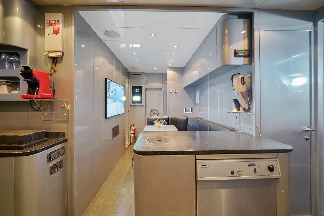 a kitchen with a counter and cabinets aboard 108' MANGUSTA 2002 Yacht for Sale
