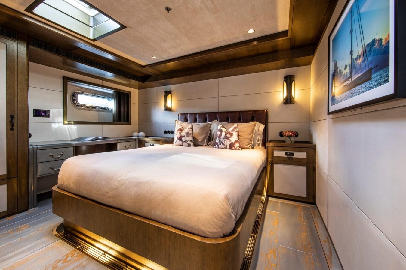 a bedroom with a bed and a tv on the wall aboard PINK GIN Yacht for Sale