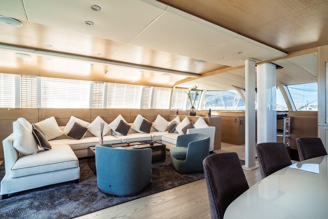a large living room with a large glass table and chairs aboard ONE FORCE Yacht for Sale