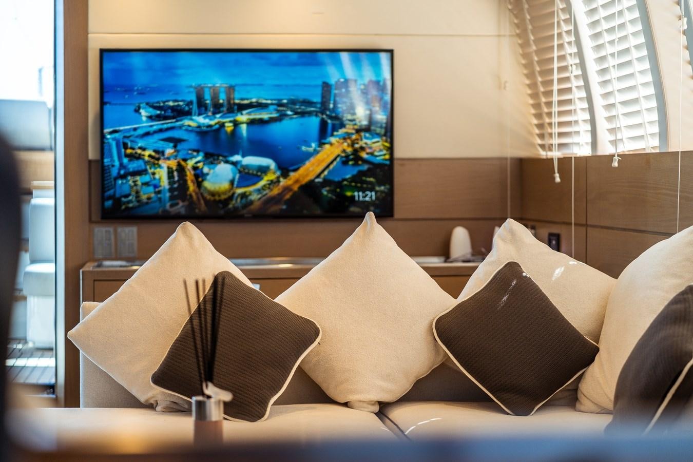 a television screen on a wall above a bed with pillows and pillows aboard ONE FORCE Yacht for Sale
