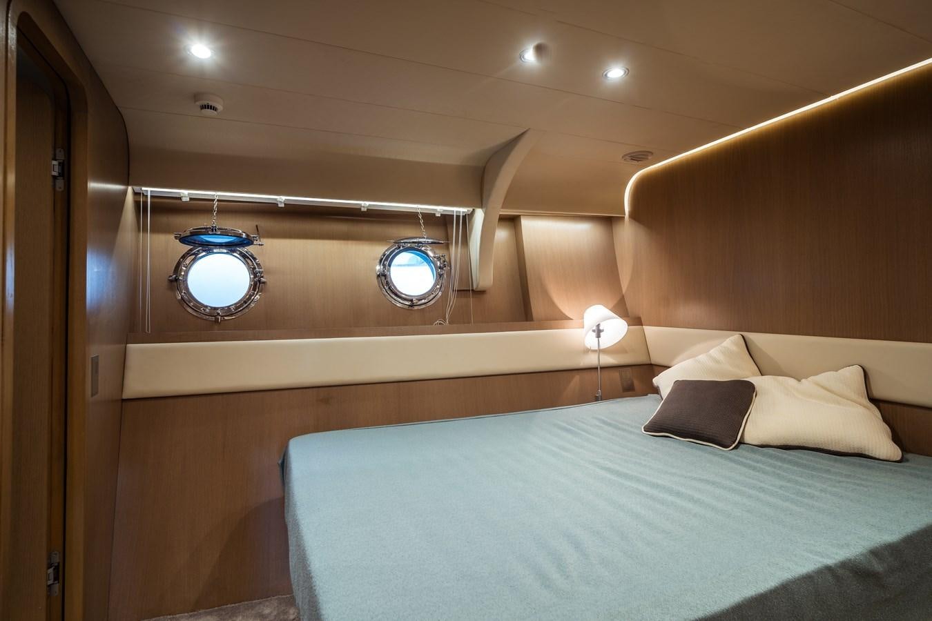 a bed with a blue bed spread aboard ONE FORCE Yacht for Sale