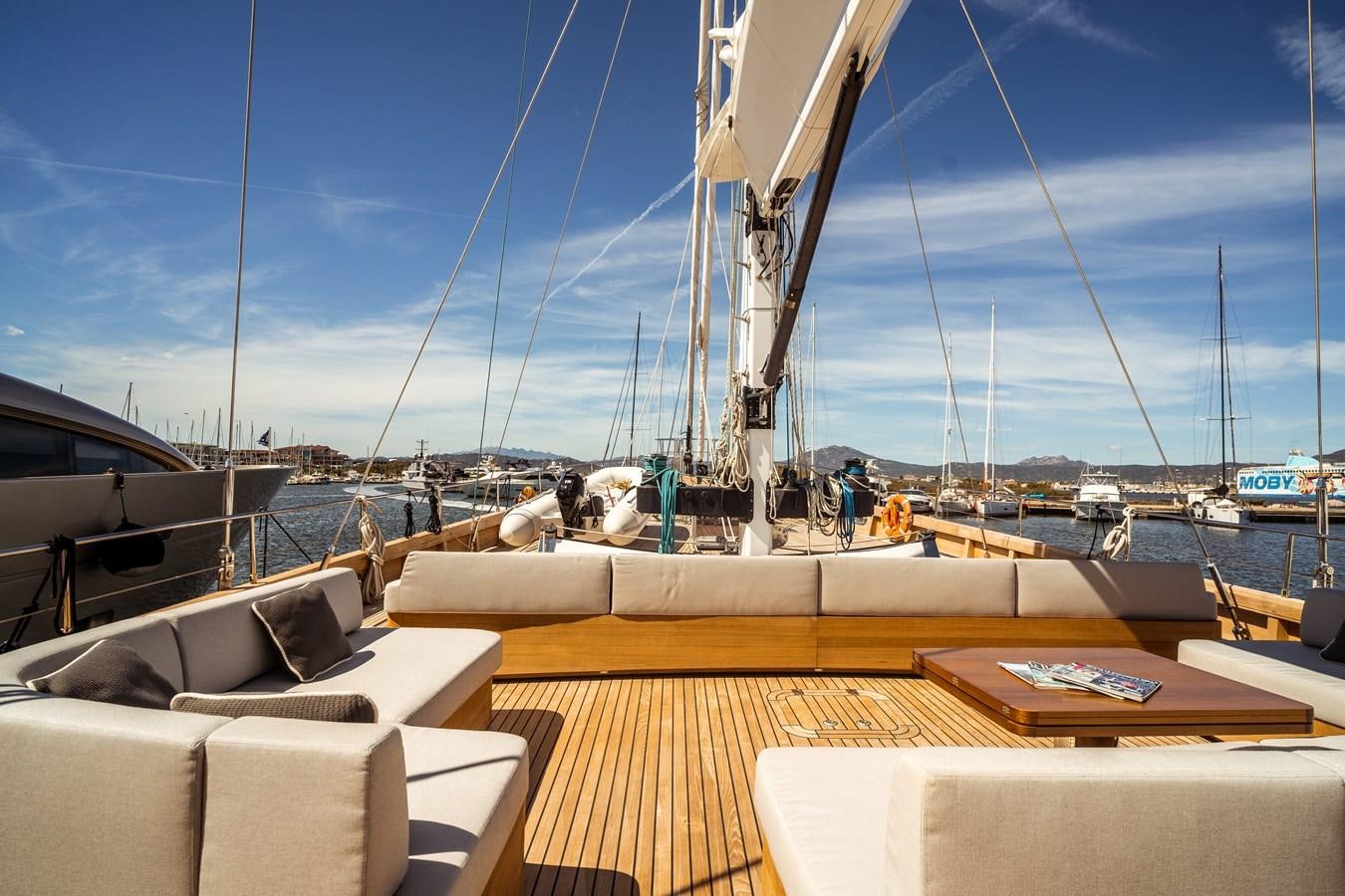 a deck with a boat and a table on it aboard ONE FORCE Yacht for Sale