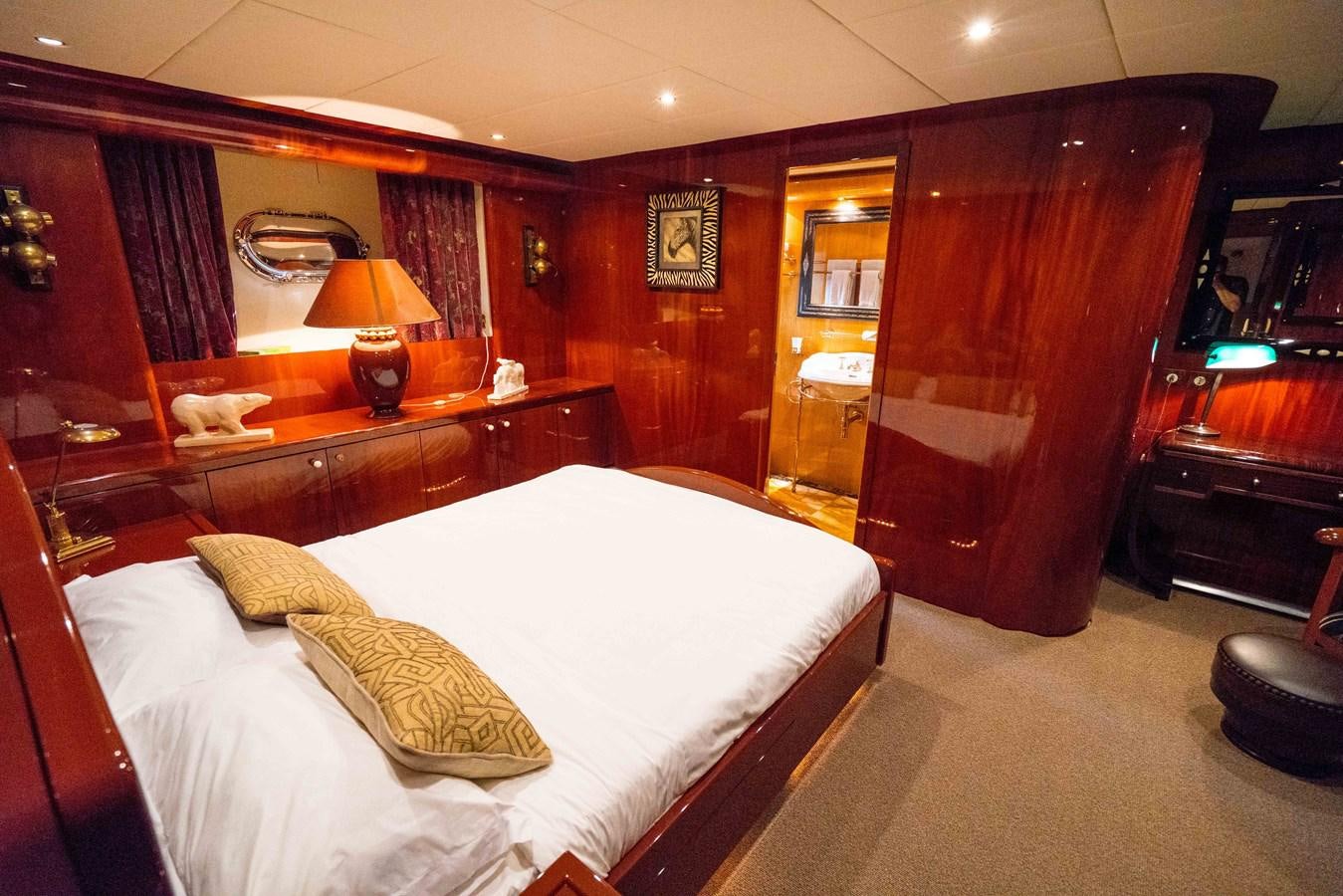 a bedroom with a bed and a lamp aboard CHASING SPIRIT Yacht for Sale