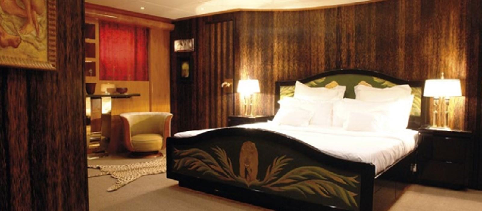 a bedroom with a bed and a chair aboard CHASING SPIRIT Yacht for Sale