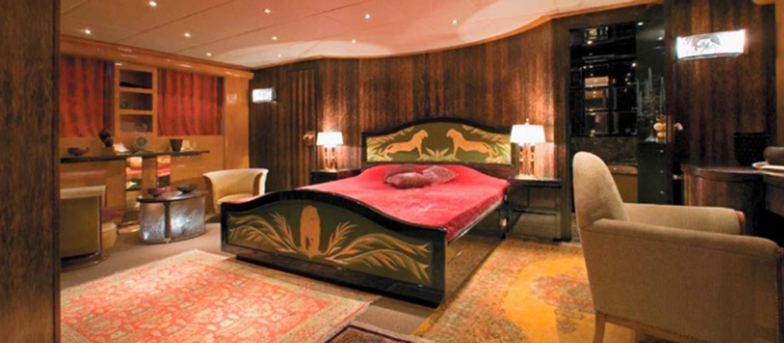 a bedroom with a bed and a chair aboard CHASING SPIRIT Yacht for Sale