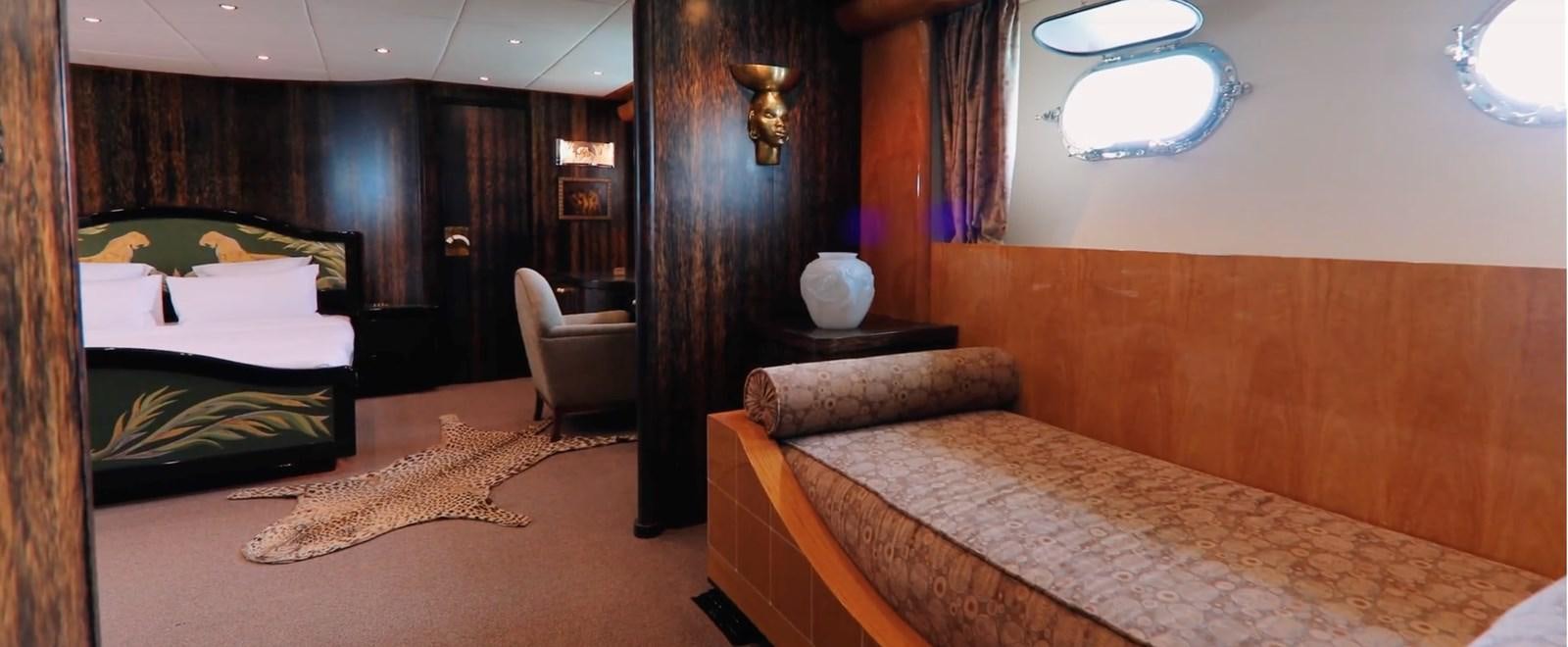 a room with a bed and a chair aboard CHASING SPIRIT Yacht for Sale