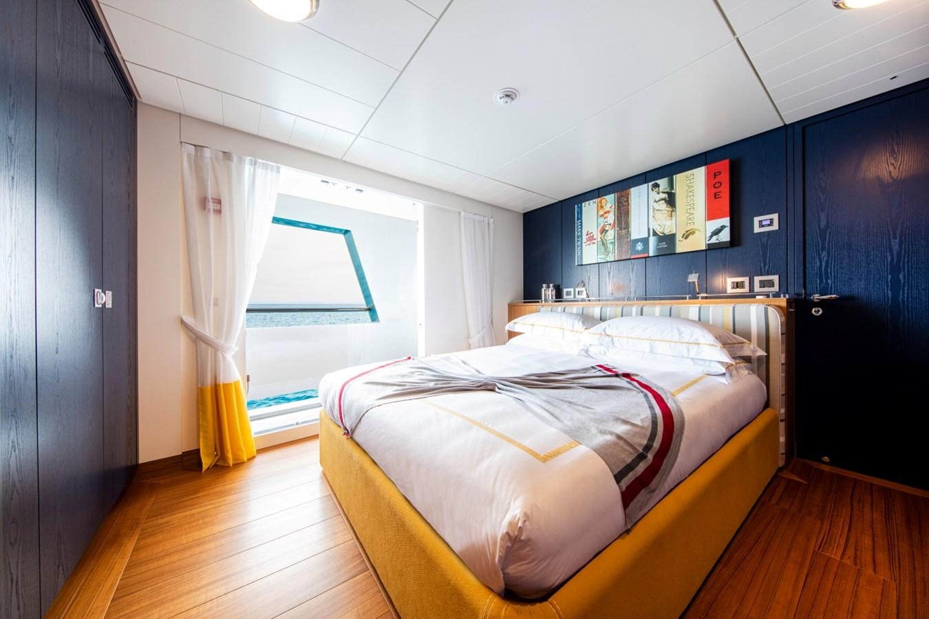 a bedroom with a bed and a window aboard AUDACE Yacht for Sale