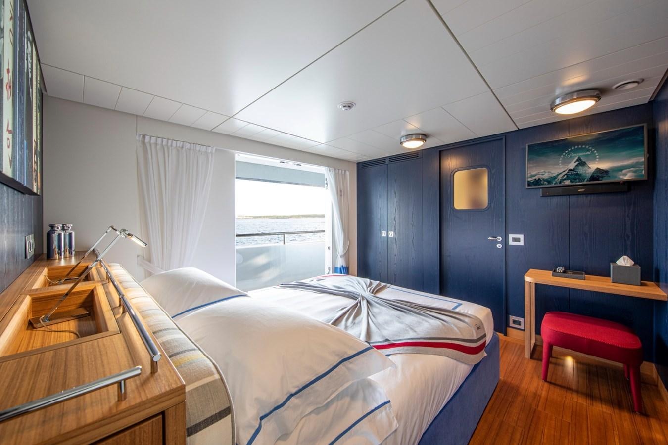 a bedroom with a bed and desk aboard AUDACE Yacht for Sale