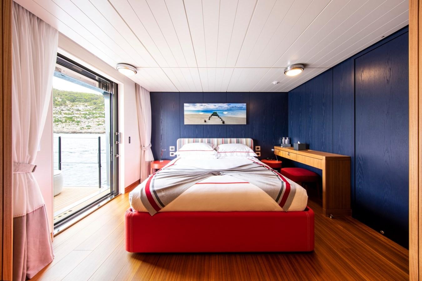 a bedroom with a bed and desk aboard AUDACE Yacht for Sale