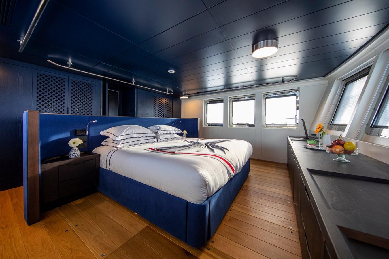 a bedroom with a bed and desk aboard AUDACE Yacht for Sale