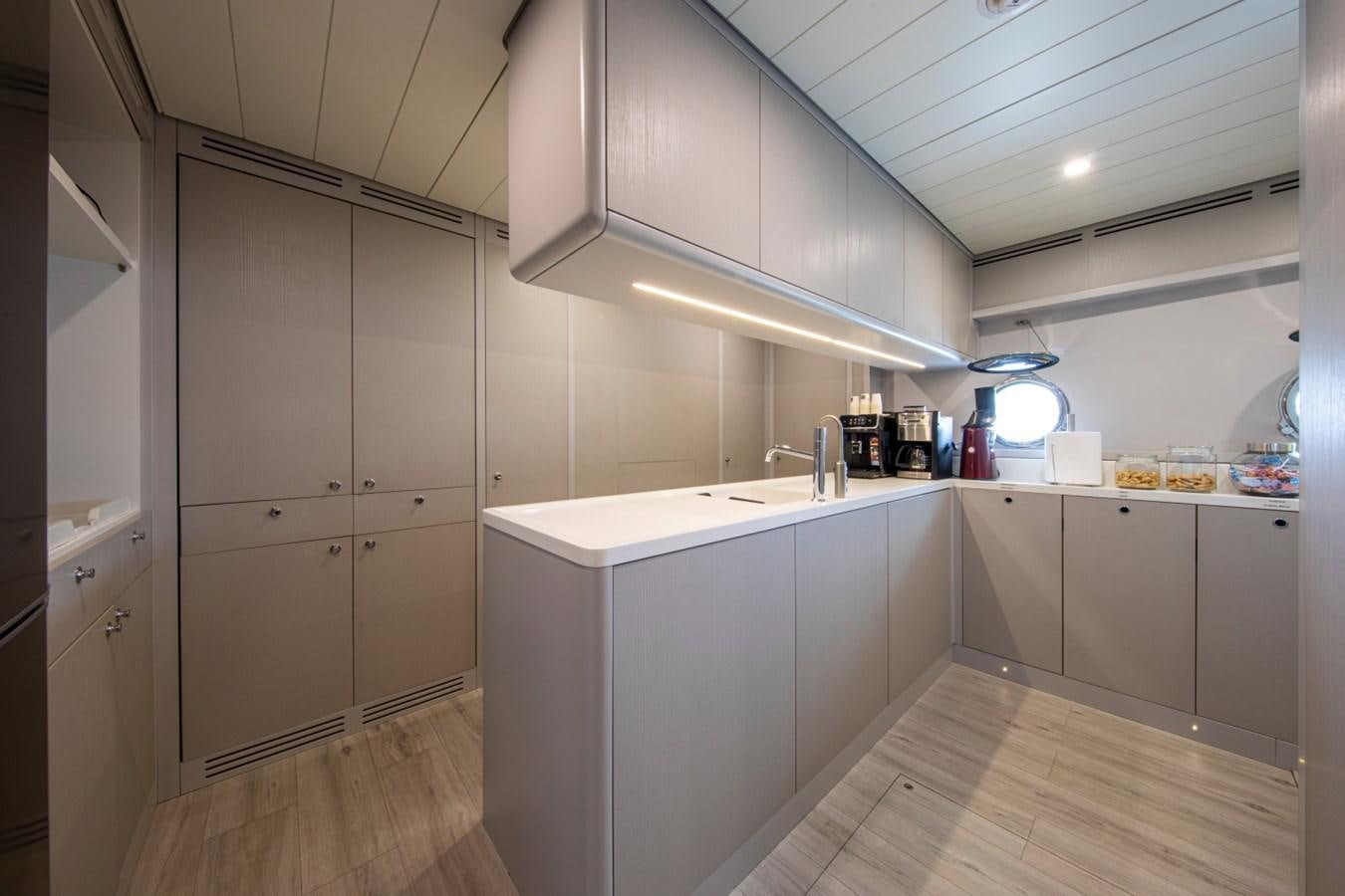 a kitchen with white cabinets aboard AUDACE Yacht for Sale