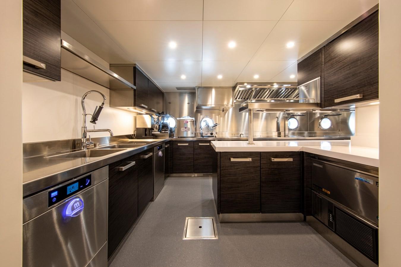 a kitchen with black cabinets aboard AUDACE Yacht for Sale