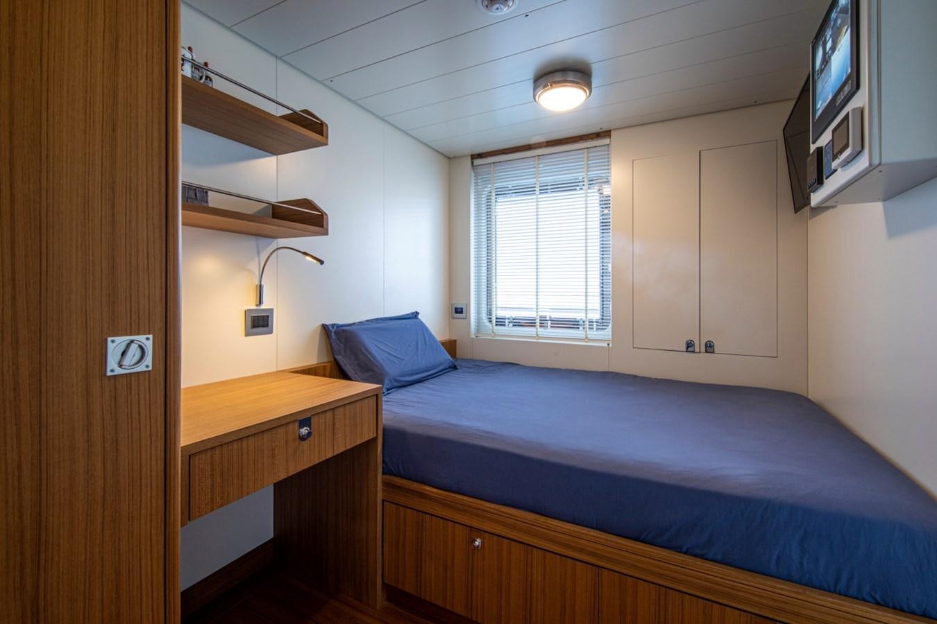 a bedroom with a bed and a desk aboard AUDACE Yacht for Sale