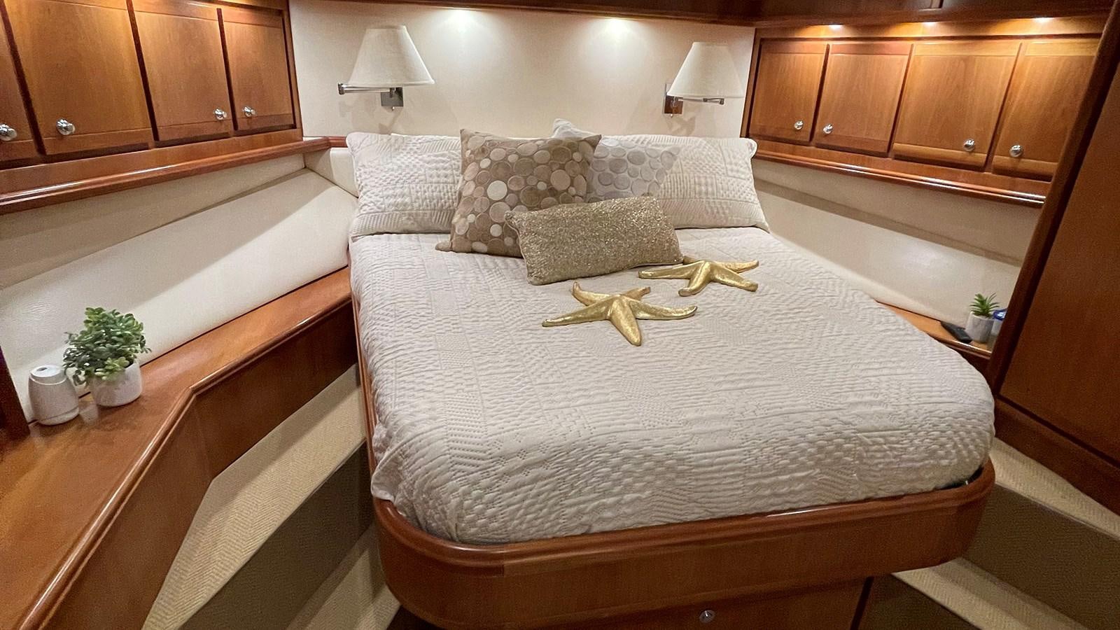 a bed with a white comforter aboard REEL BUSY Yacht for Sale