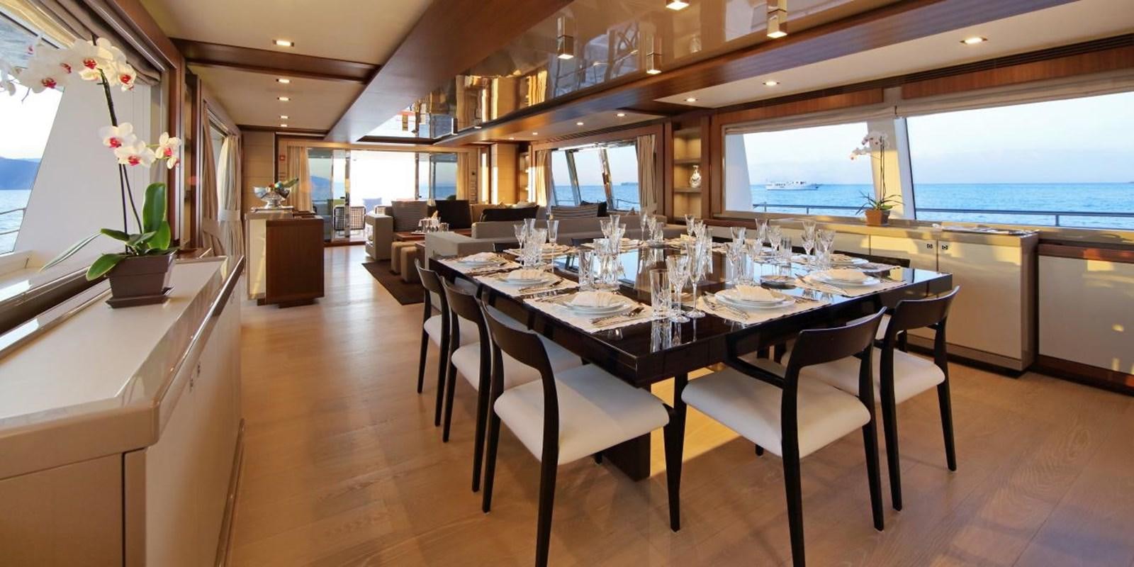 a dining table with chairs aboard VELA Yacht for Sale