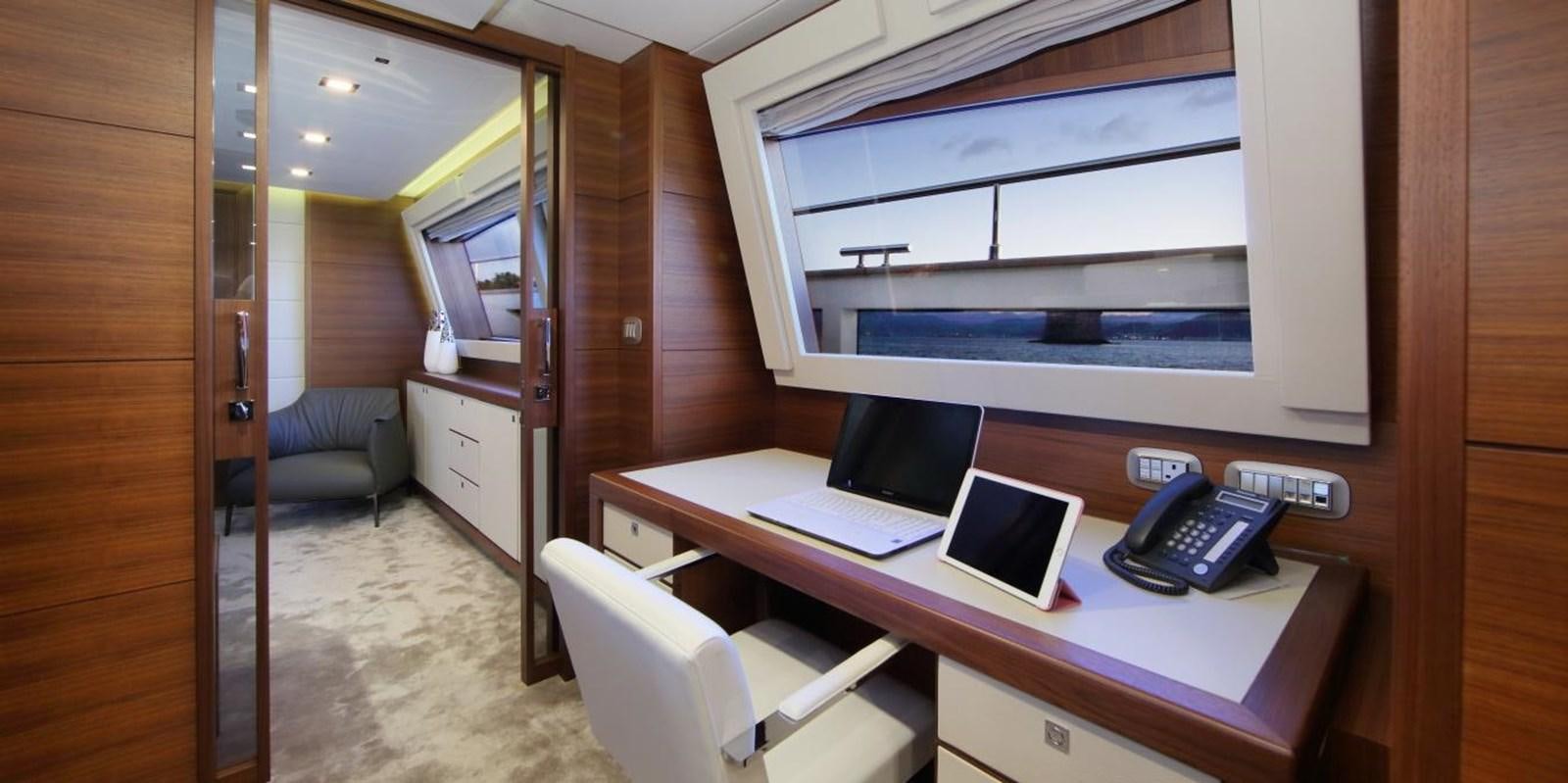 a room with a desk and a phone aboard VELA Yacht for Sale