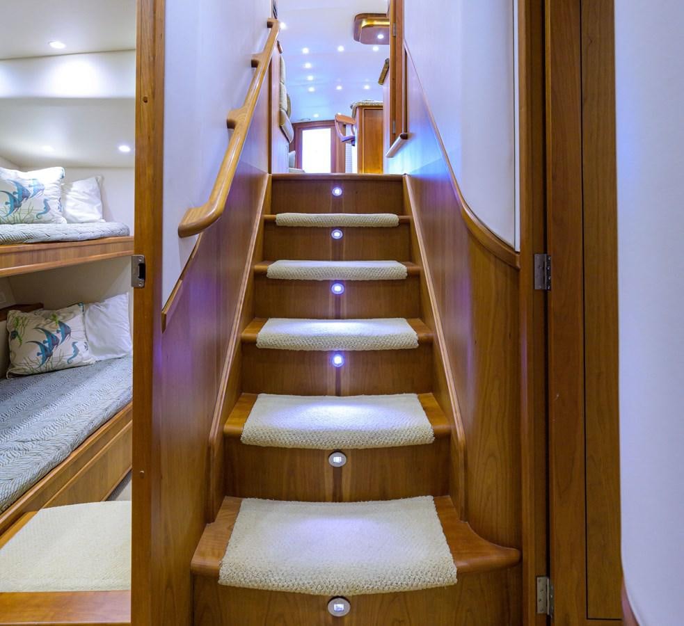 a wooden staircase with a bed and a white wall aboard GEORGIA GIRL Yacht for Sale
