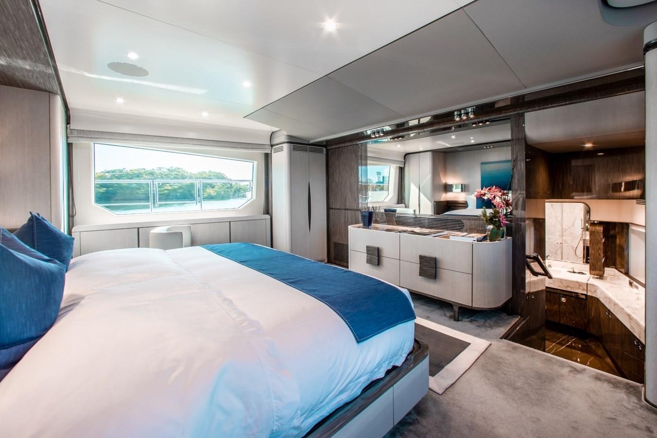 a bedroom with a bed and a desk aboard INDIGO Yacht for Sale