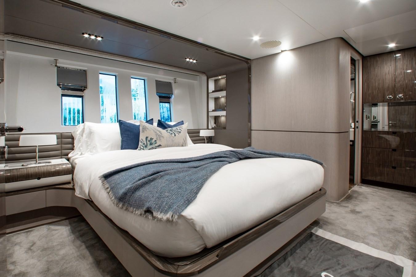 a bedroom with a bed and a wood cabinet aboard INDIGO Yacht for Sale