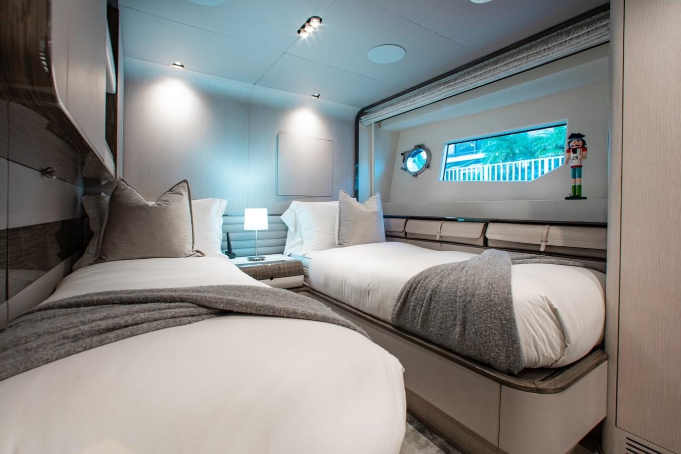 a room with two beds and a tv on the wall aboard INDIGO Yacht for Sale