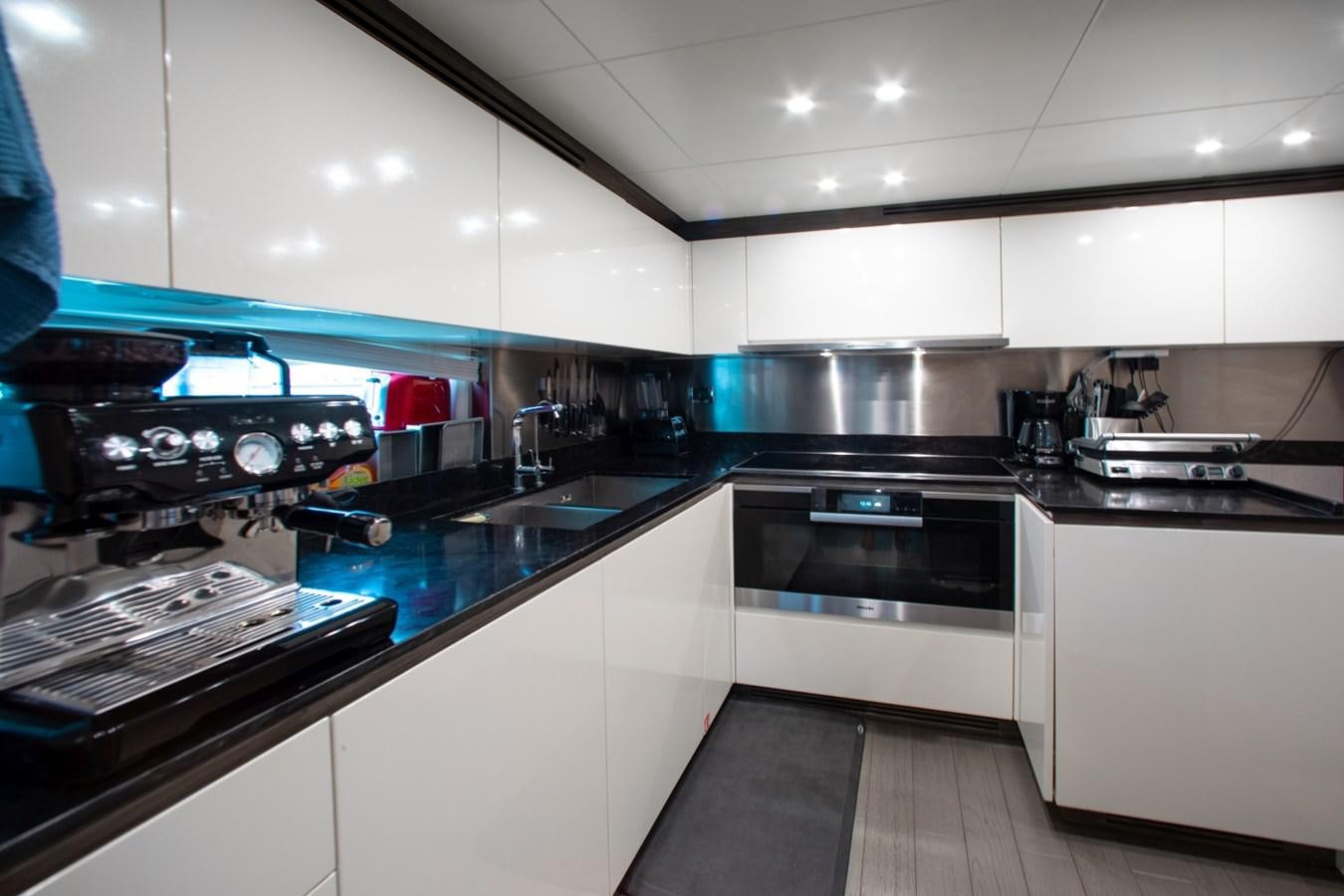 a kitchen with white cabinets aboard INDIGO Yacht for Sale