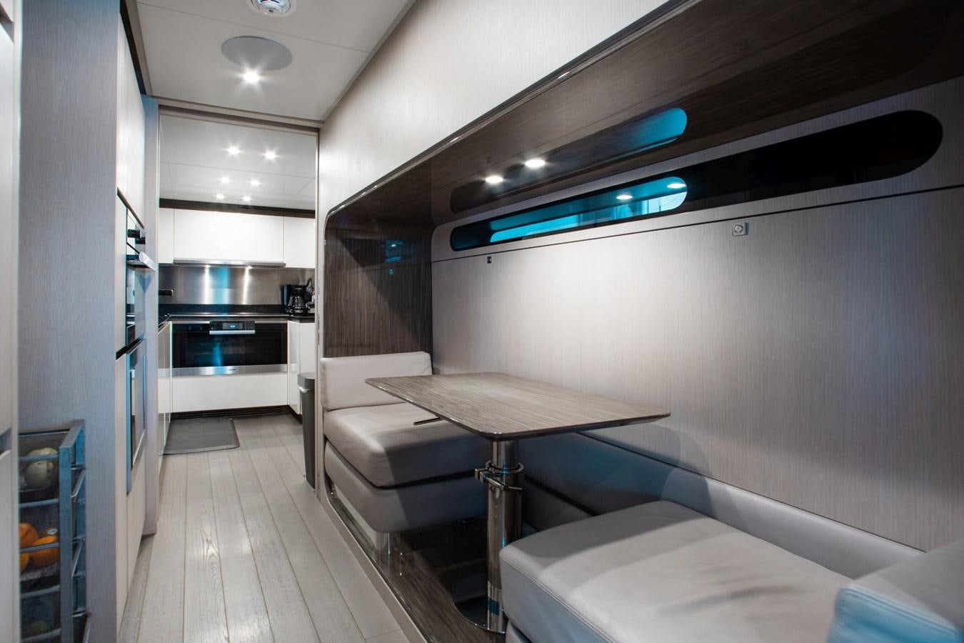 a room with a table and a bed aboard INDIGO Yacht for Sale