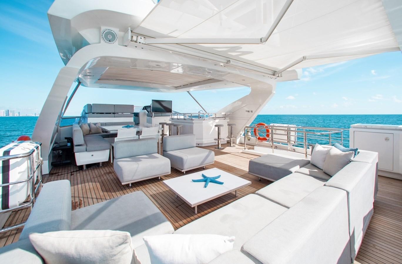 a large white lounge chair on a deck next to a large body of water aboard INDIGO Yacht for Sale
