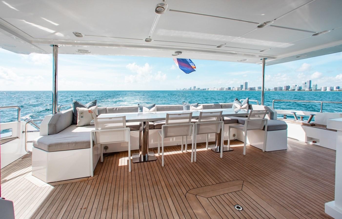 a room with a table chairs and a beach aboard INDIGO Yacht for Sale
