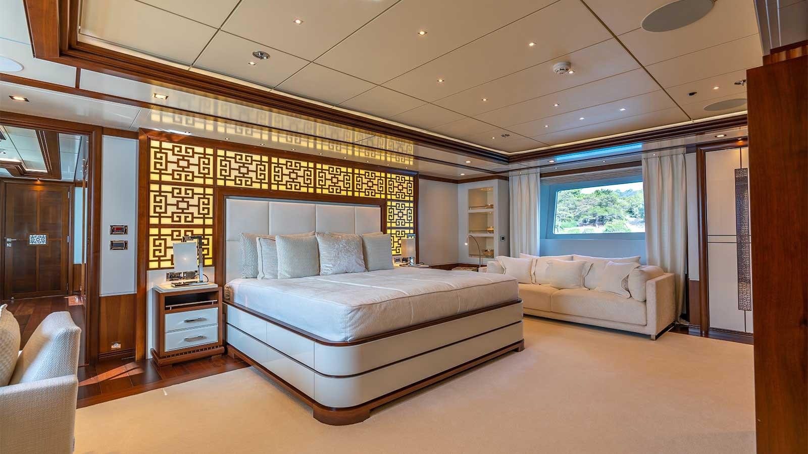 a large bedroom with a bed and a couch aboard IMMERSIVE Yacht for Sale