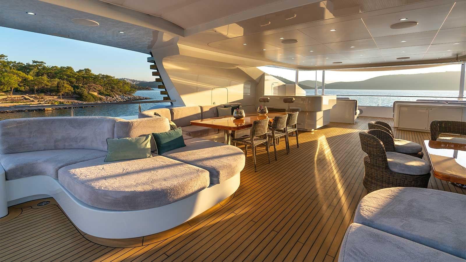 a large room with a bed and chairs aboard IMMERSIVE Yacht for Sale