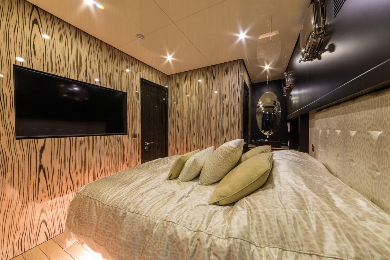 a bed with a television on the wall aboard EMANUEL Yacht for Sale