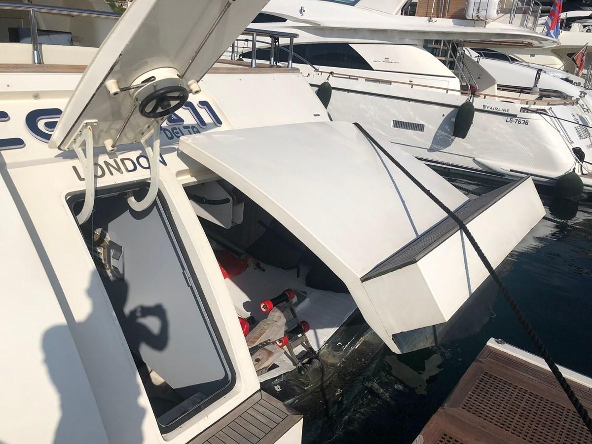 a white boat with a white surfboard on it aboard OCEAN DELTA 11 Yacht for Sale