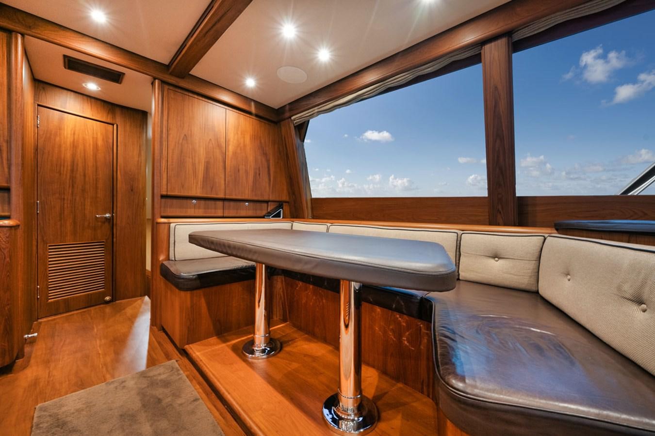 a room with a table and a couch aboard OWL'S NEST Yacht for Sale