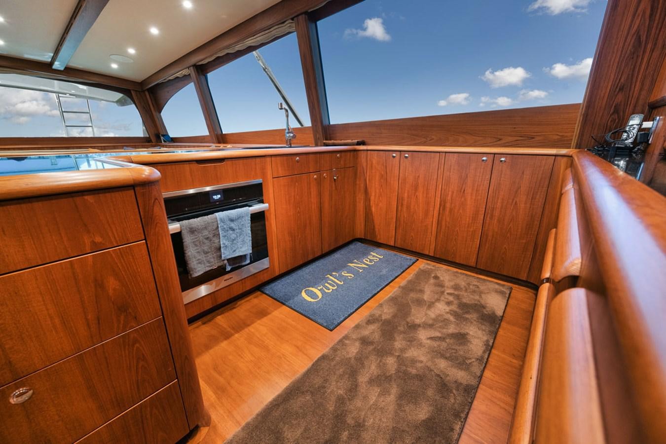 a room with wooden cabinets and a rug on the floor aboard OWL'S NEST Yacht for Sale