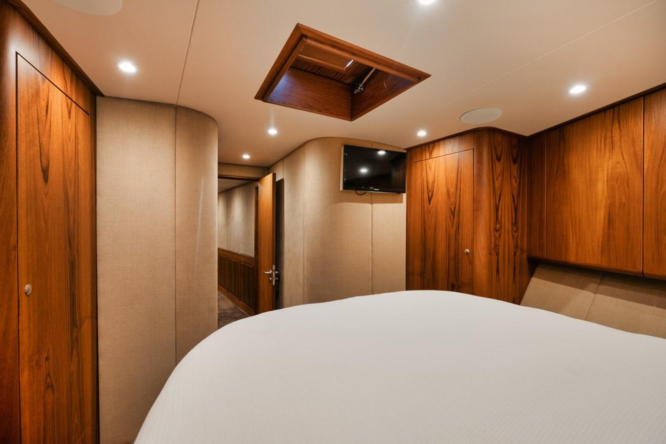 a room with a bed and a television on the wall aboard OWL'S NEST Yacht for Sale