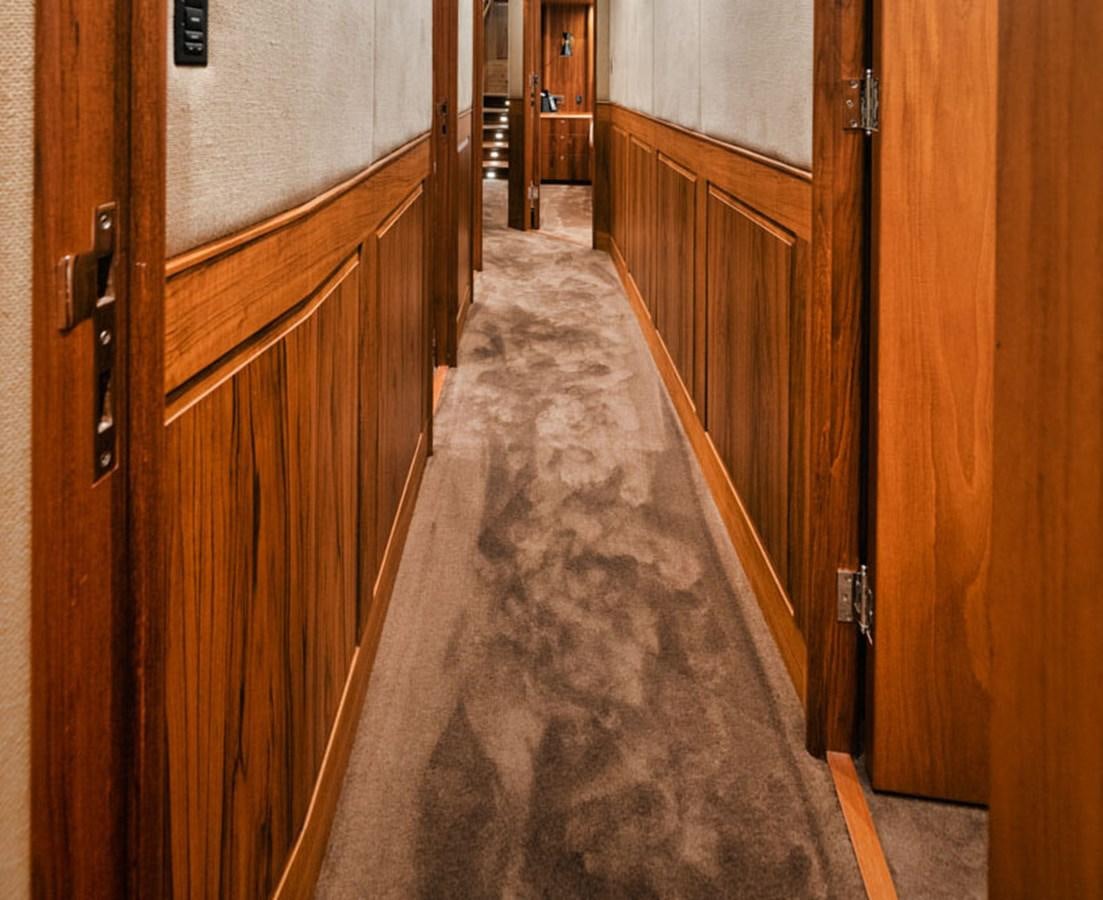a long hallway with wooden cabinets aboard OWL'S NEST Yacht for Sale