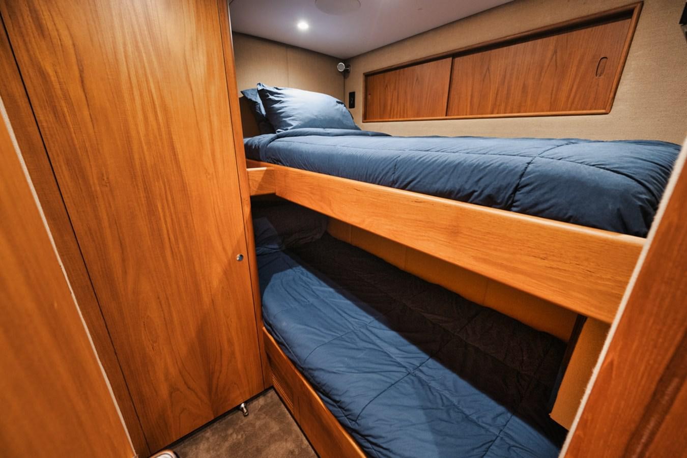 a bed with a blue comforter aboard OWL'S NEST Yacht for Sale