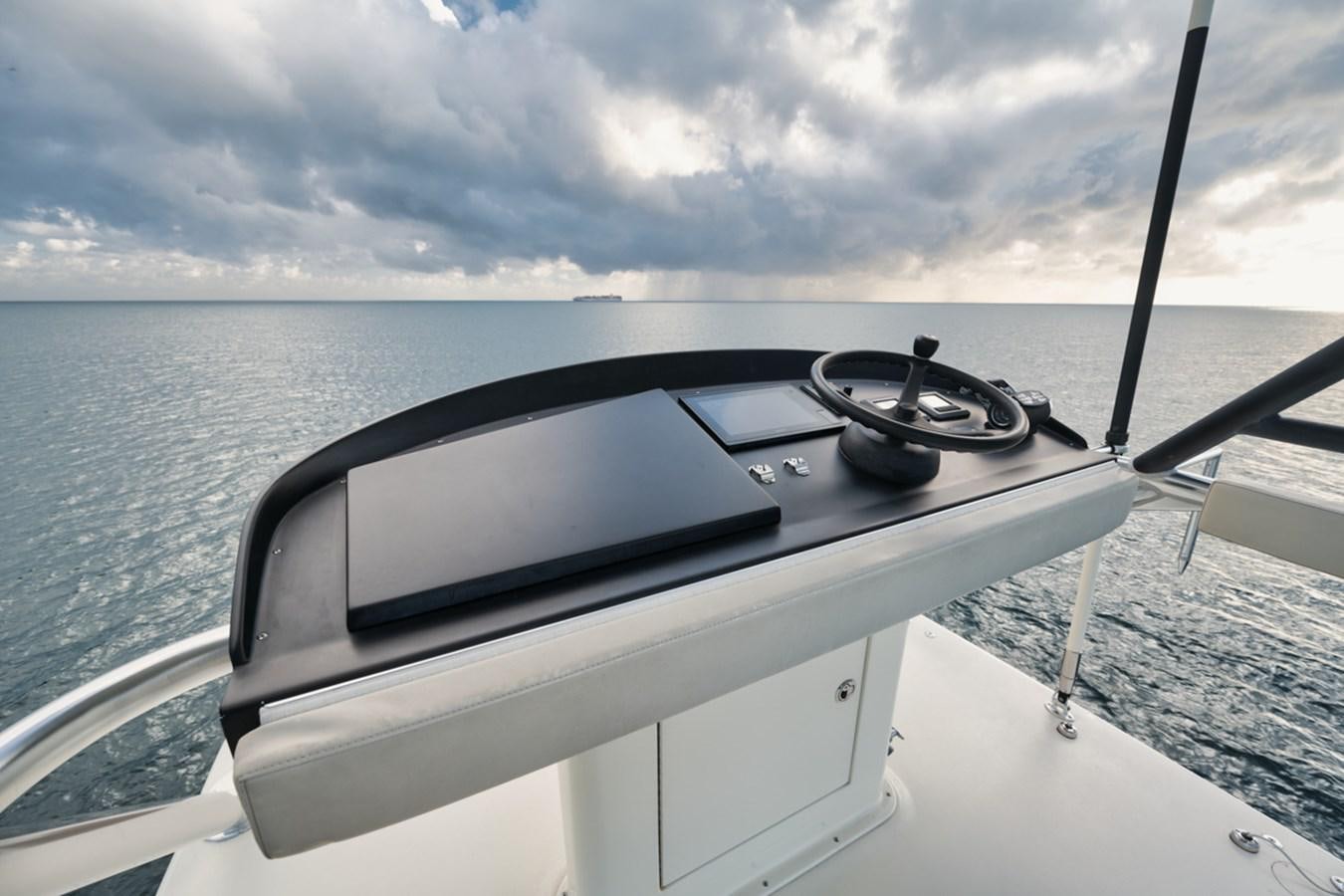 a boat with a steering wheel and a view of the water aboard OWL'S NEST Yacht for Sale