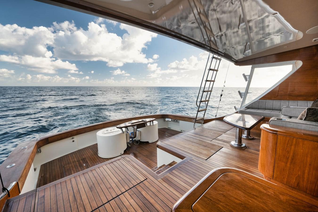 a deck with a large body of water and a large boat in the background aboard OWL'S NEST Yacht for Sale