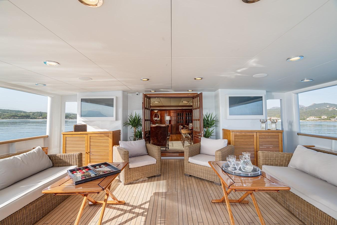 a living room with a table and couches aboard AQUARIUS IV Yacht for Sale