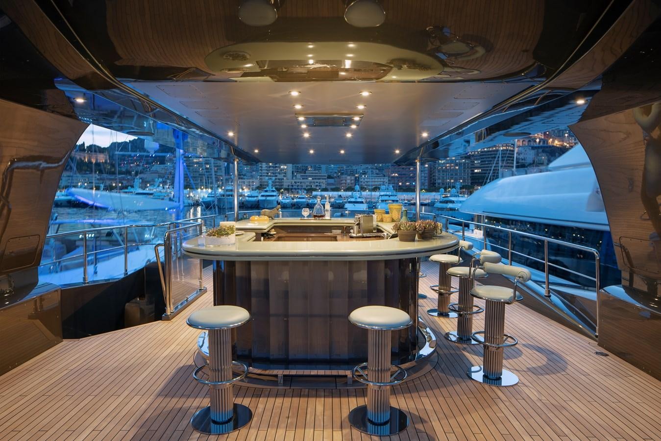 a room with a table and stools aboard MRS L Yacht for Sale
