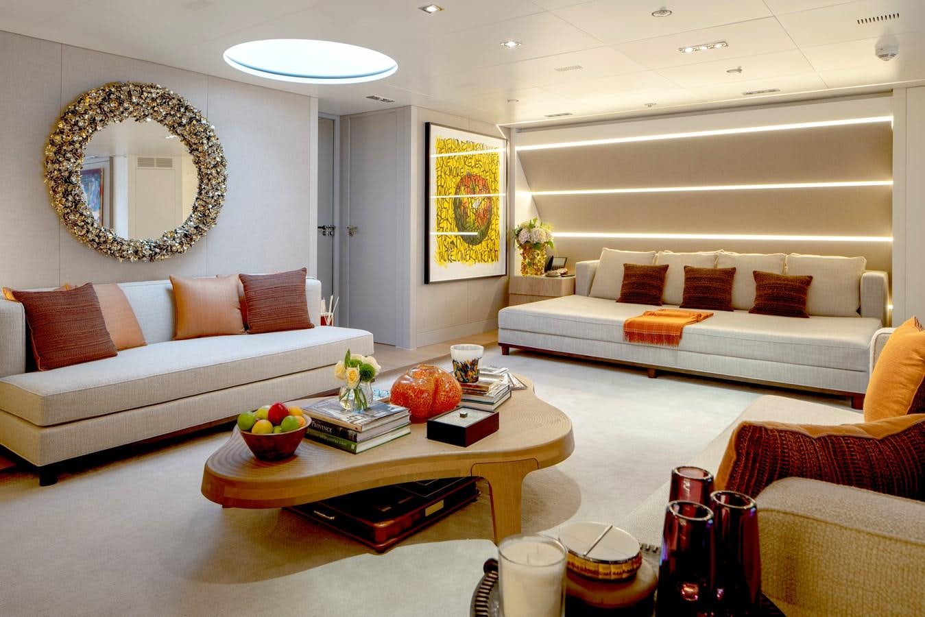 a living room with a white couch and a round mirror aboard MRS L Yacht for Sale
