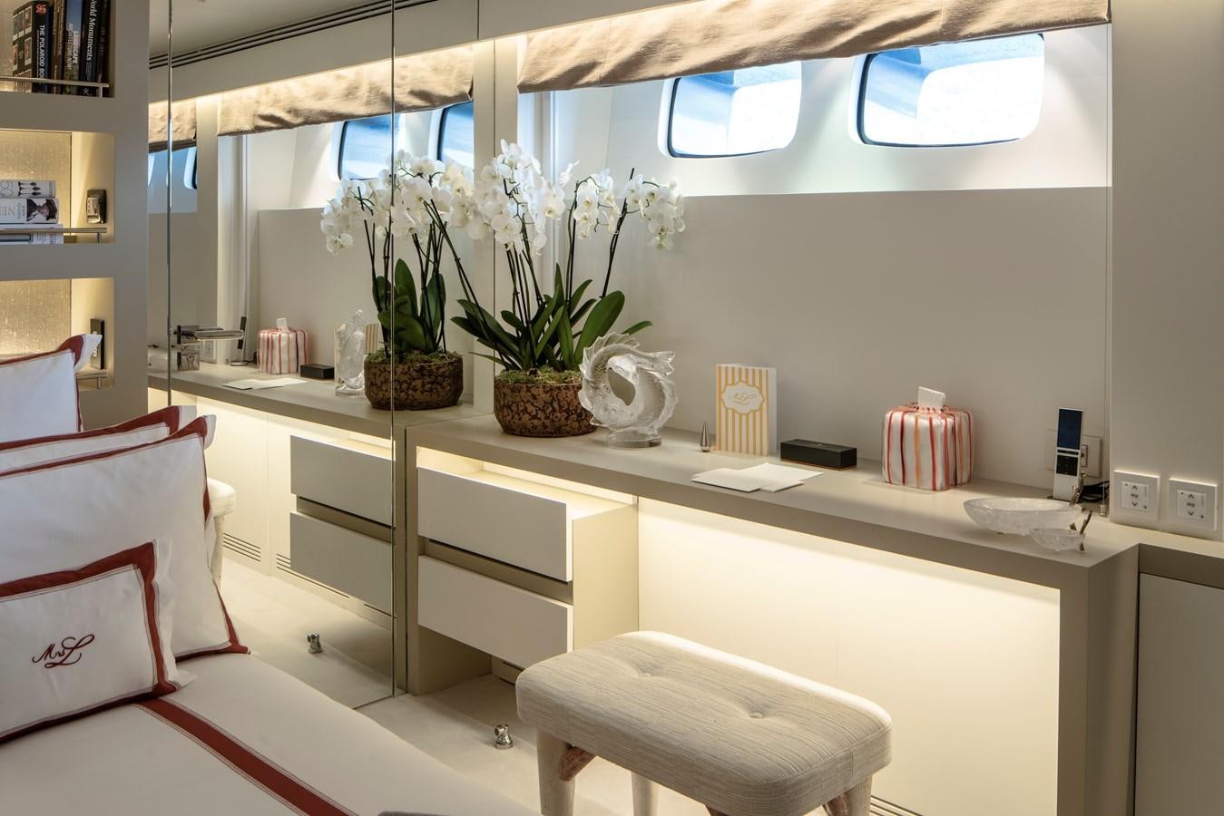 a white desk with a plant in a room with a window aboard MRS L Yacht for Sale