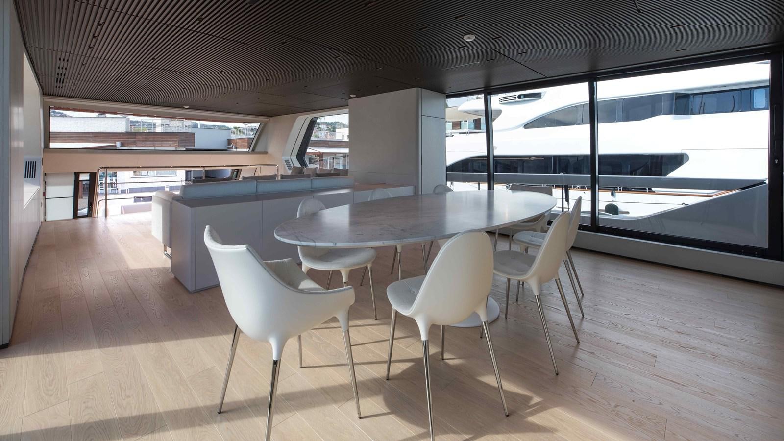 a room with tables and chairs aboard SP110-03 Yacht for Sale