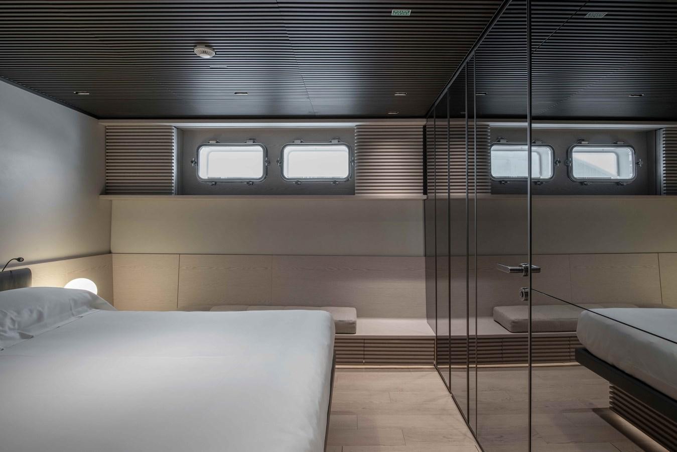 a room with a bed and a glass wall aboard SP110-03 Yacht for Sale