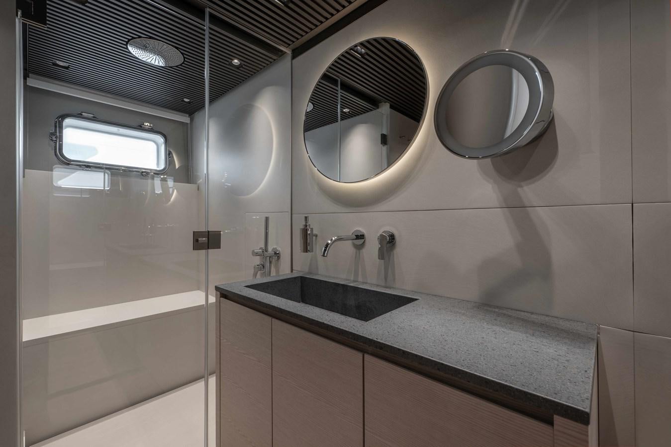 a bathroom with a round mirror aboard SP110-03 Yacht for Sale